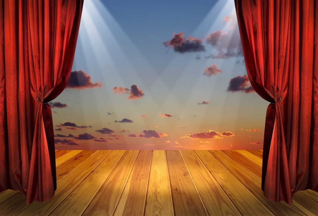 Image of a stage with open curtains revealing a blue sky