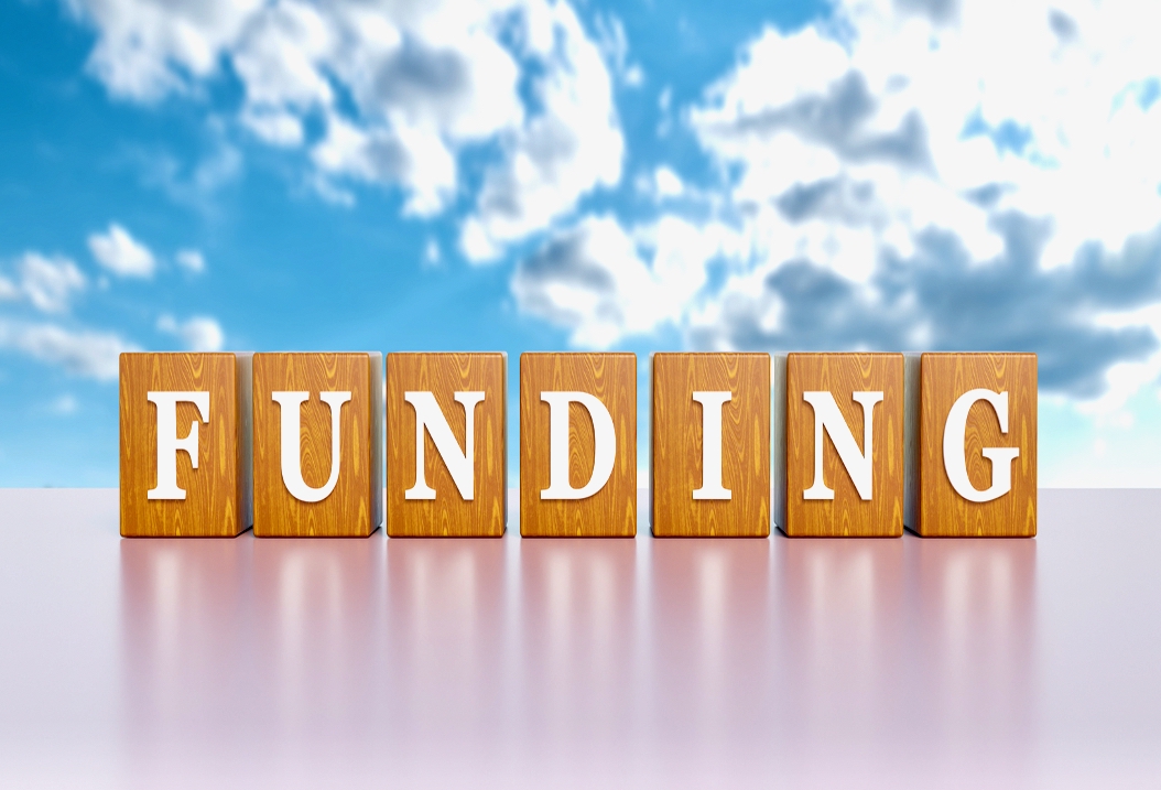 Image of letters forming word FUNDING across sky background