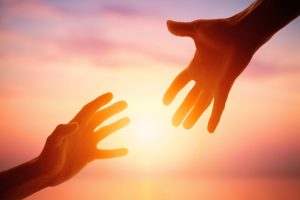 Hand reaching for another, hope, uplifting
