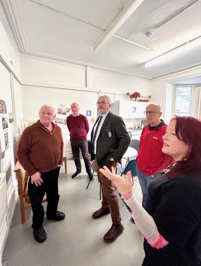 Photo of people looking at a wall of photos