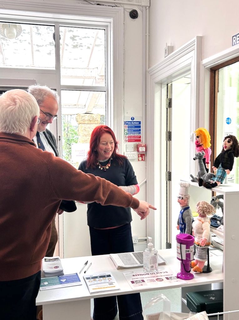 Group of people amused by knitted dolls
