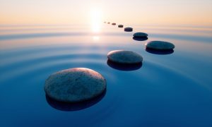 Image of stones over water going into sunrise: positive, calm