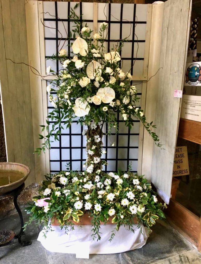 Photo of display of white flowers in shape of a cross